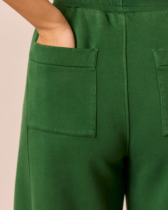 model wears lyra verdant green fleeceback jersey trousers right