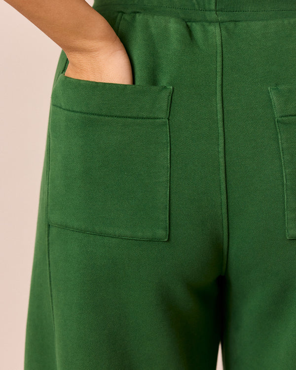 model wears lyra verdant green fleeceback jersey trousers right
