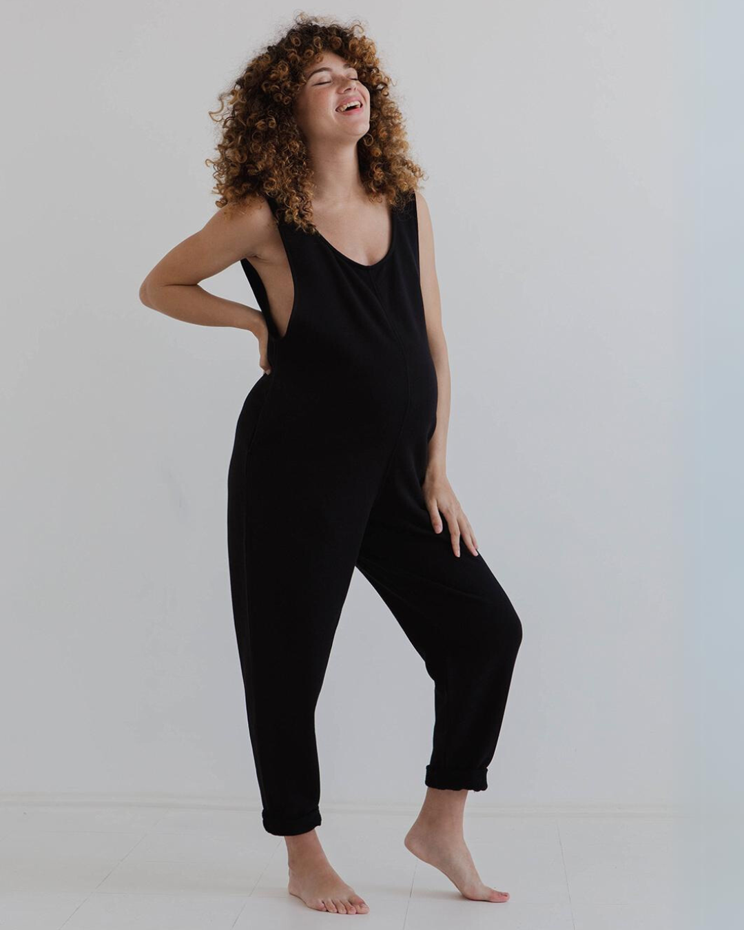 pregnant model wears black laura jumpsuit