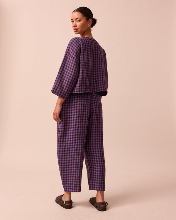 model wears mabel blueberry gingham linen trousers left