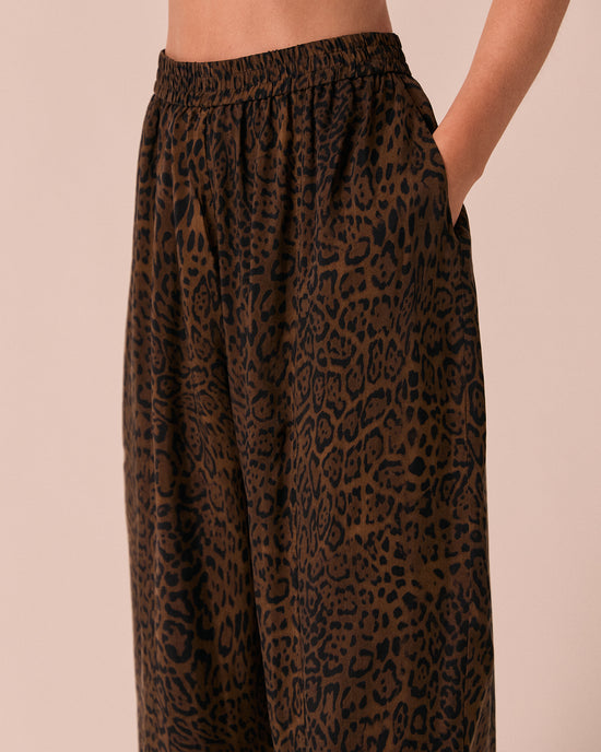 model wears mabel dark leopard cupro trousers left
