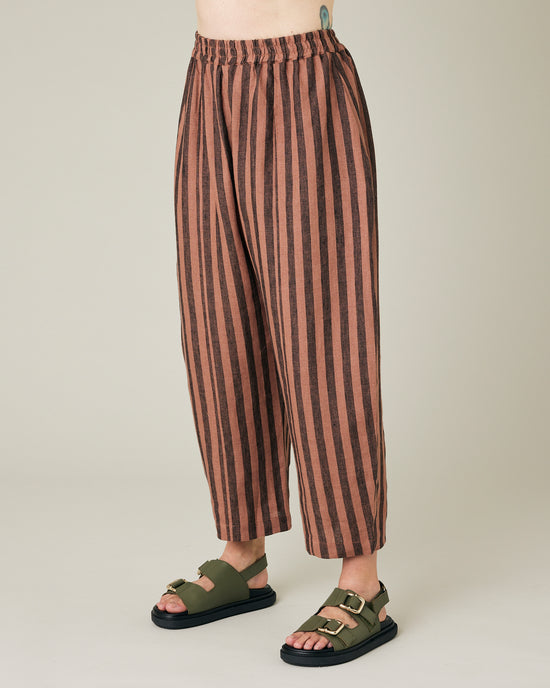 model wears longer length biscuit stripe mabel trousers left