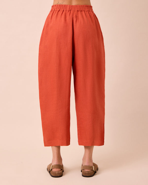model wears mabel burnt orange linen trousers back