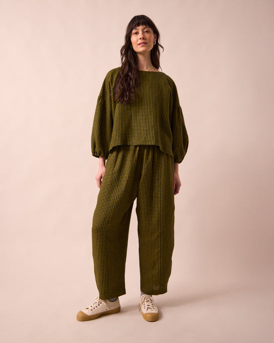 model wears mabel fresh olive mini gingham linen trousers left