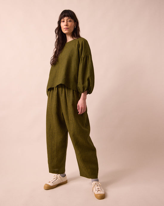 model wears mabel fresh olive mini gingham linen trousers right