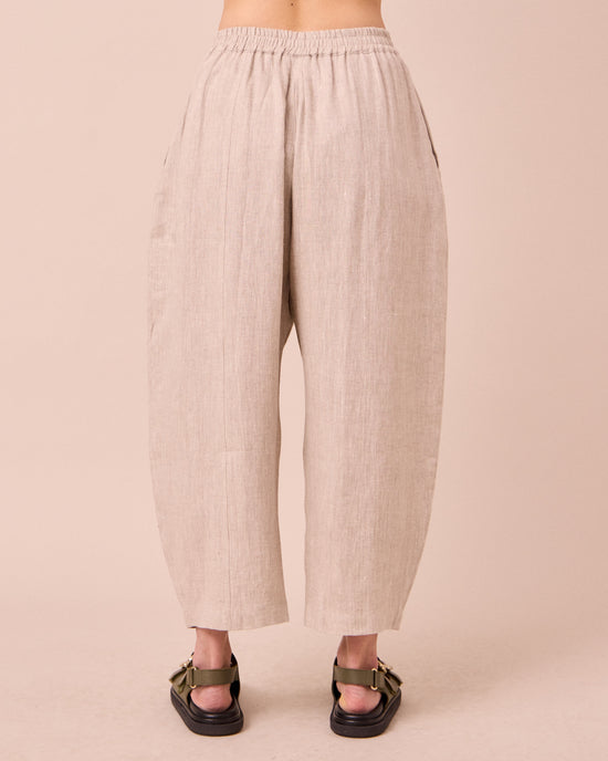 model wears mabel natural linen trousers back