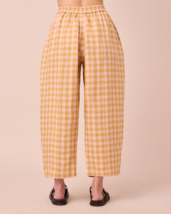 model wears mabel ochre gingham linen trousers back