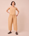 model wears mabel ochre gingham linen trousers left