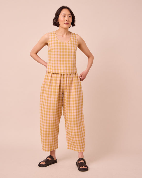 model wears mabel ochre gingham linen trousers left