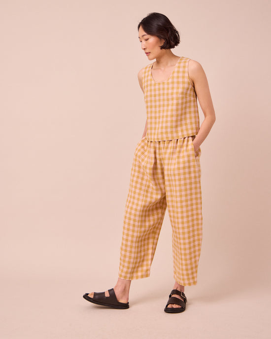 model wears mabel ochre gingham linen trousers right