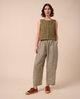 model wears mabel olive gingham linen trousers left