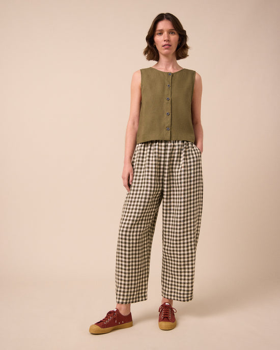 model wears mabel olive gingham linen trousers left