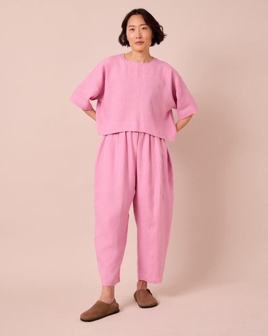 model wears mabel rose pink linen trousers right