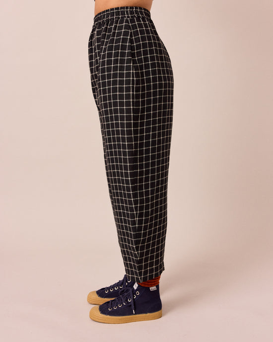 model wears mabel black grid linen trousers left