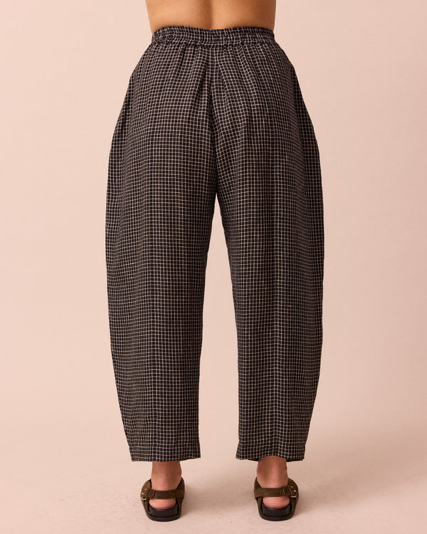 model wears mabel black mini grid linen trousers back