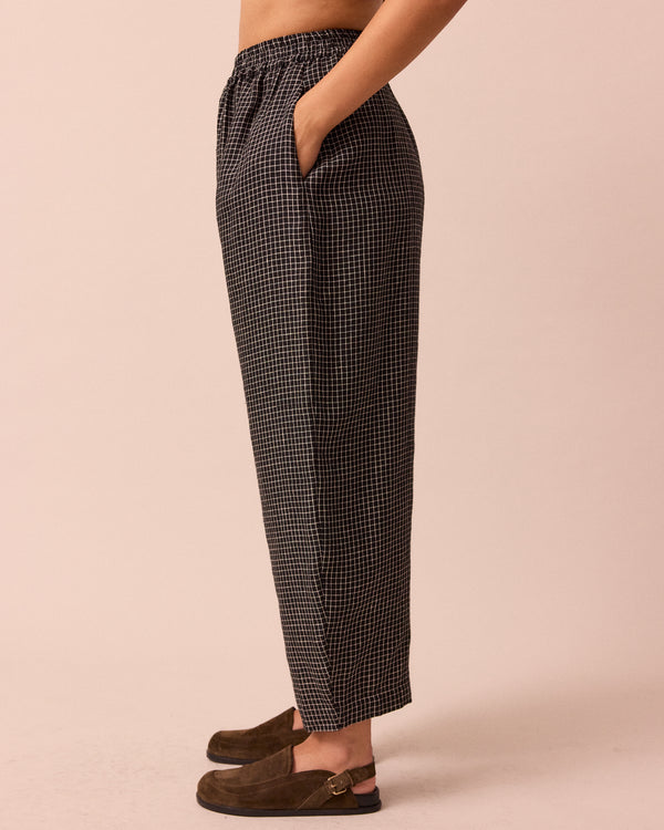 model wears mabel black mini grid linen trousers left