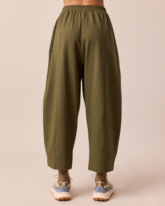 model wears mabel light olive jersey trousers back