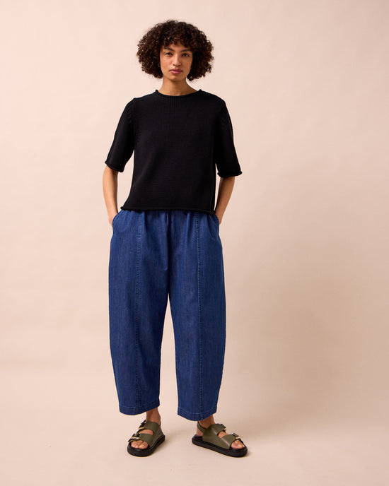 model wears mabel mid blue light denim trousers left