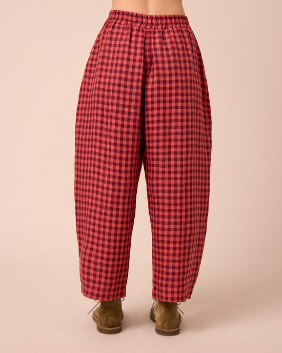 model wears mabel deep rose gingham linen trousers back