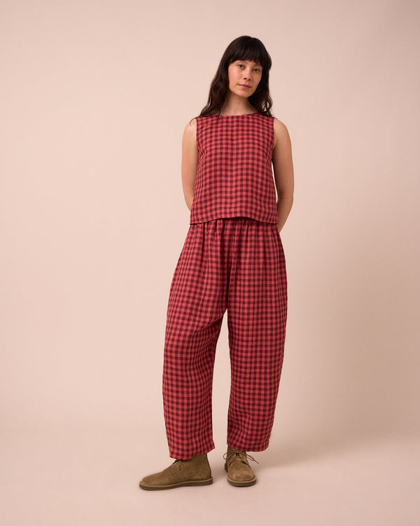 model wears mabel deep rose gingham linen trousers left
