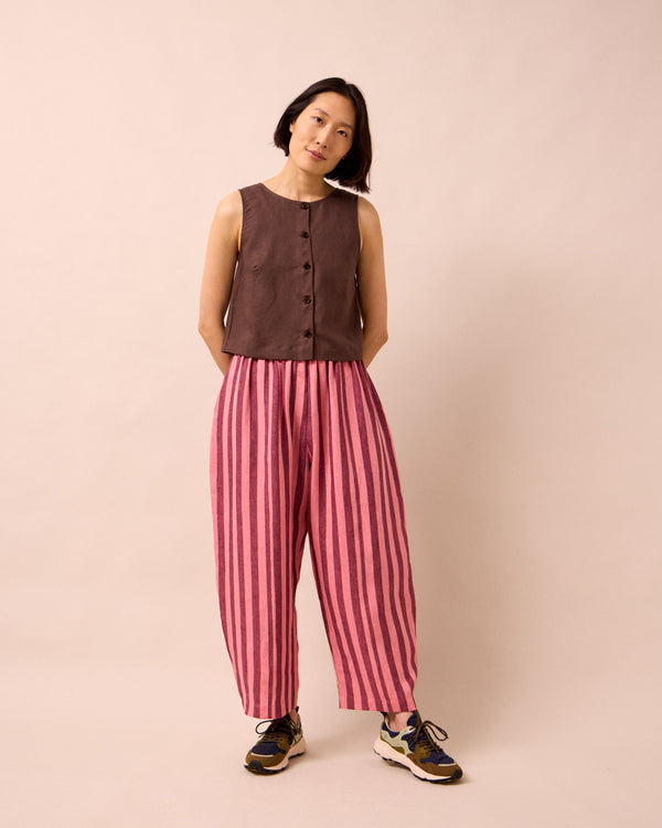 model wears mabel fiesta pink linen trousers right