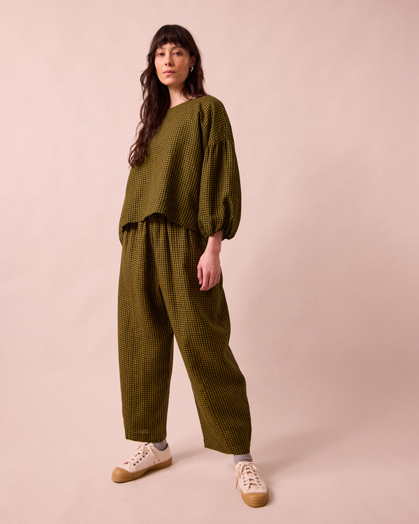 model wears mabel fresh olive mini gingham linen trousers right