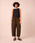 model wears mabel rust stripe linen trousers left