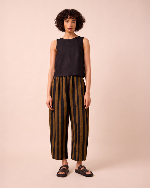 model wears mabel rust stripe linen trousers left