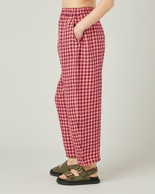model wears blush gingham mabel linen trousers left
