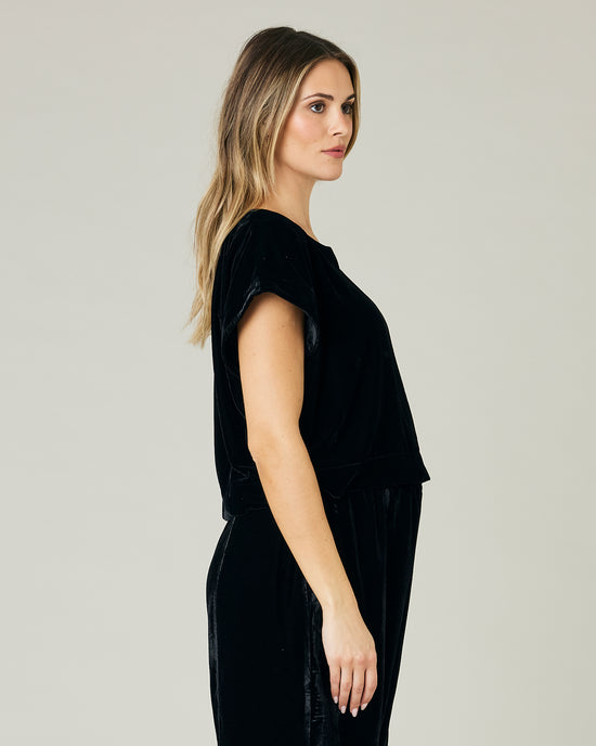 pregnant model wears black velvet polly top and velvet trousers