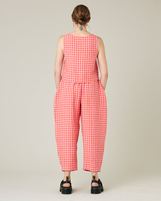 model wears longer length tomato and pink check linen mabel trousers