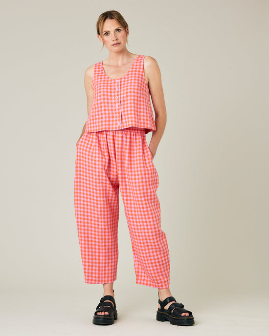 model wears longer length tomato and pink check linen mabel trousers