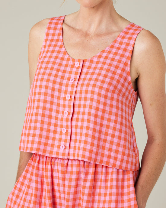 model wears pink and tomato check betty top