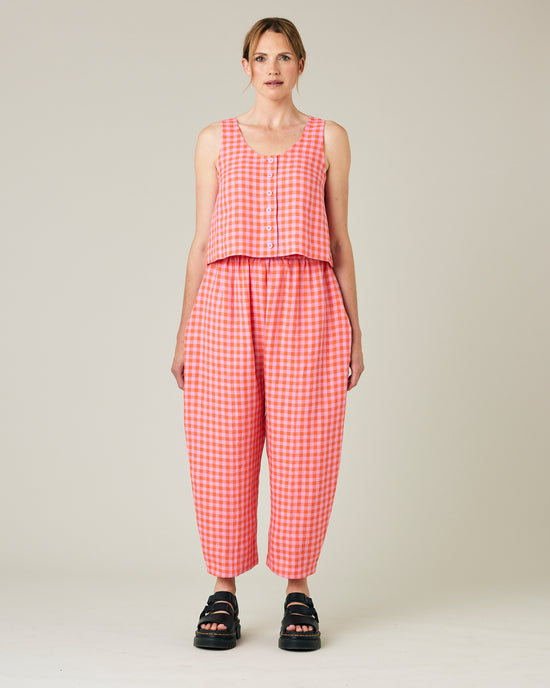 model wears longer length tomato and pink check linen mabel trousers