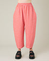 model wears longer length tomato and pink check linen mabel trousers front