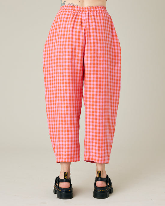 model wears longer length tomato and pink check linen mabel trousers back