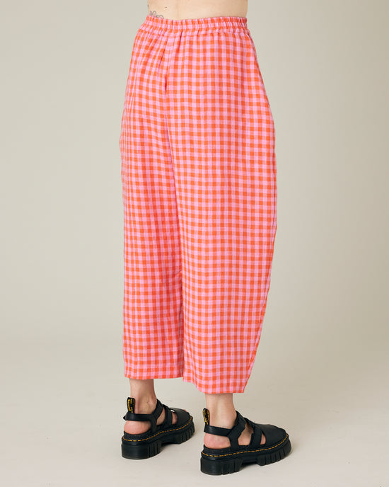 model wears longer length tomato and pink check linen mabel trousers right