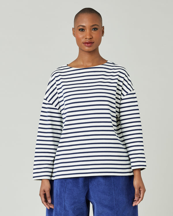 model wears ecru and navy striped breton top