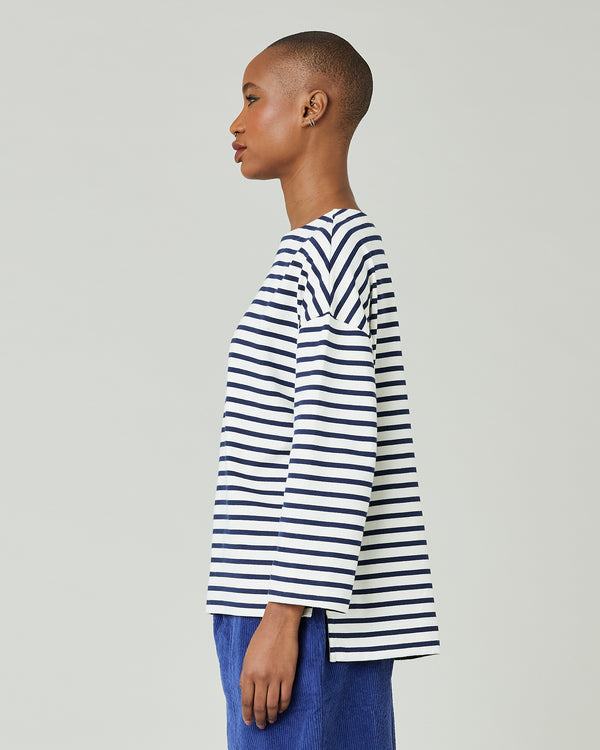 model wears ecru and navy striped breton top
