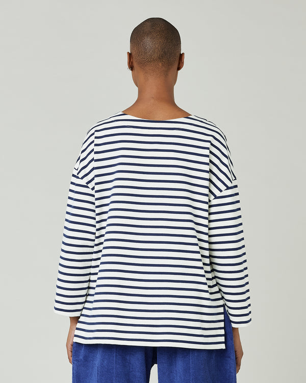 model wears ecru and navy striped breton top