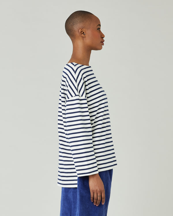 model wears ecru and navy striped breton top