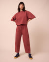 model wears madi brick jersey trousers left