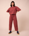 model wears madi brick jersey trousers left