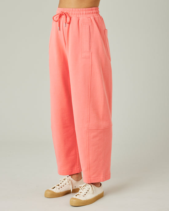 model wears shrimp pink madi trousers left