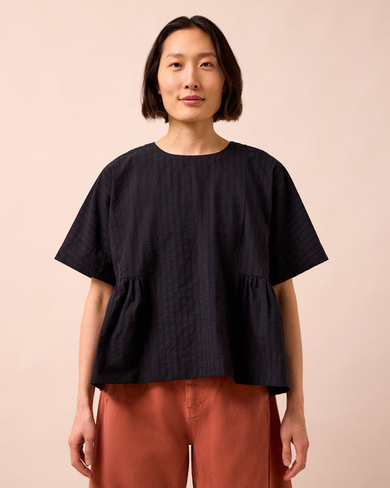 model wears marlow black self stripe cotton top