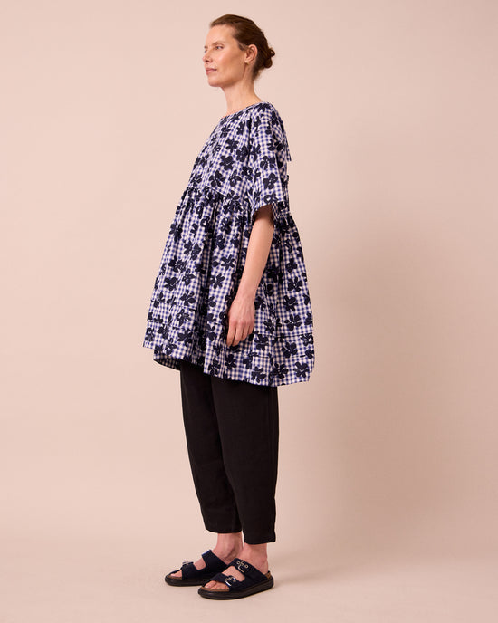 model wears neve floral stamped gingham linen dress