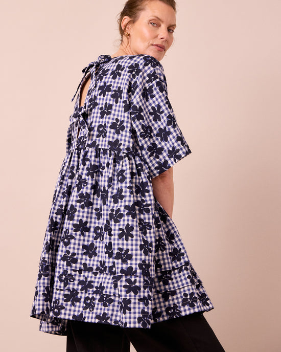 model wears neve floral stamped gingham linen dress
