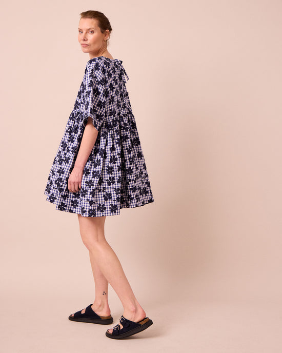model wears neve floral stamped gingham linen dress