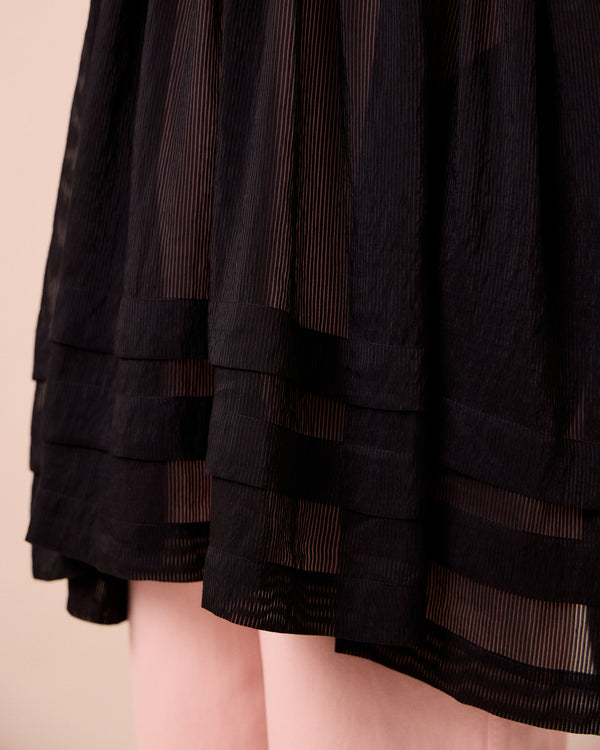 model wears neve black sheer stripe dress