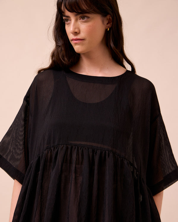 model wears neve black sheer stripe dress
